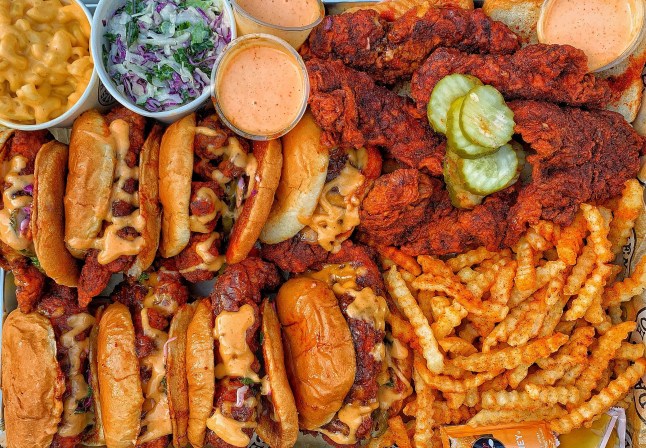A massive tray of fries, sliders and chicken tenders from Dave's Hot Chicken, with slaw and sauces