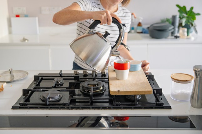 Woman making cup of tea on the hob