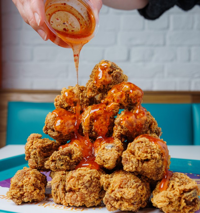 Hot Honey sauce being drizzled on chicken wings at Popeyes