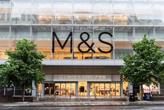 Manchester City Centre, Manchester/UK - July 6 2019: Marks & Spencer store front on Market Street in Manchester City Centre. No people in shot. Trees either side with glass front M&S logos; Shutterstock ID 1445264891; purchase_order: -; job: -; client: -; other: -