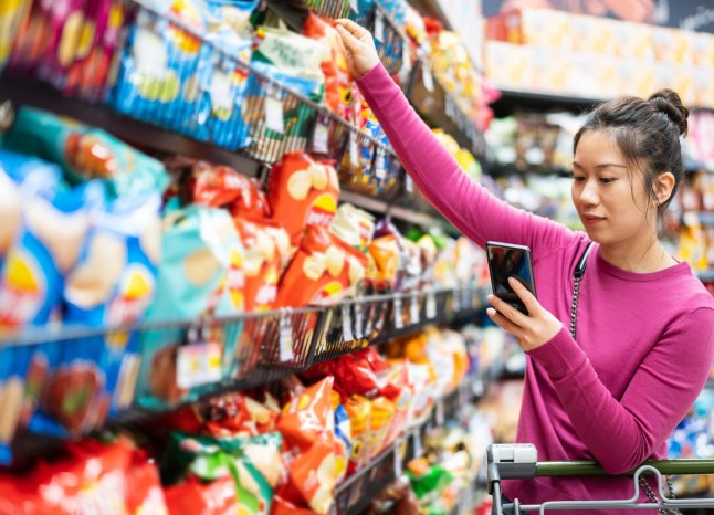 Woman shopping in supermarket crisp aisle