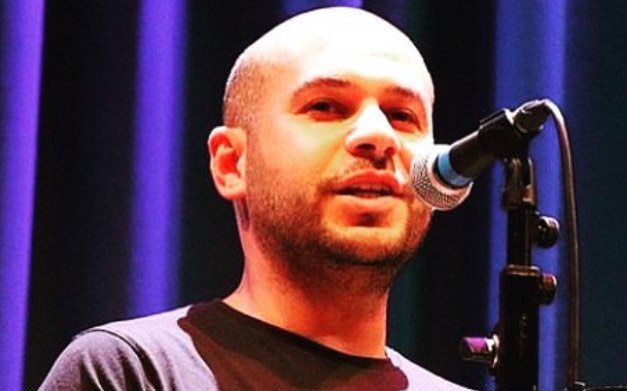 Amro Tabari speaks into a microphone on stage